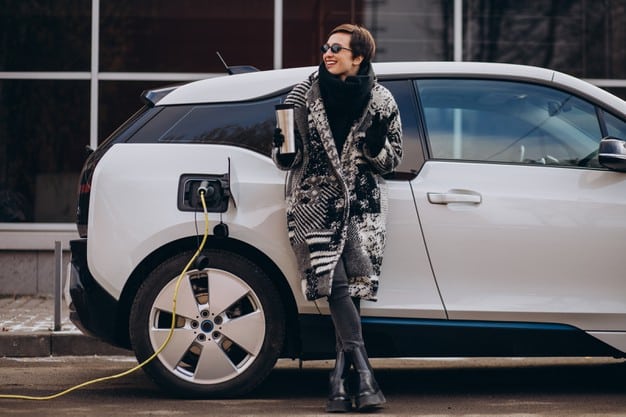 woman-charging-electro-car-street_1303-25979